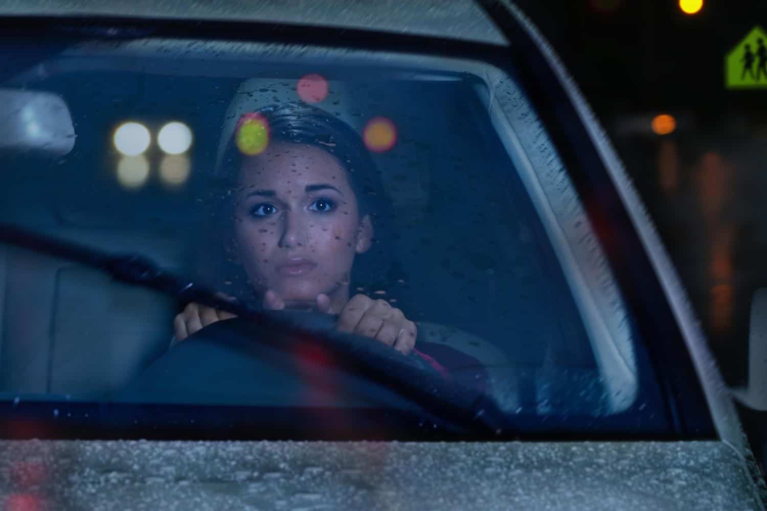 femme conduisant de nuit sous la pluie