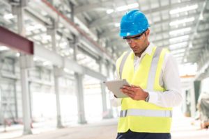 contractor-adhering-to-safety-rules-on-site-940x627 ouvrier prenant des notes sur sa tablette