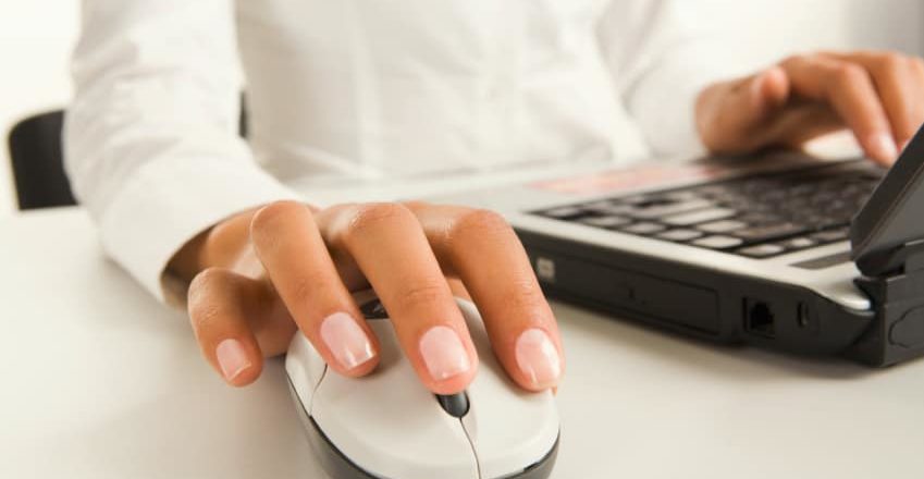 gros plan sur les mains d'une employée utilisant son ordinateur et sa souris