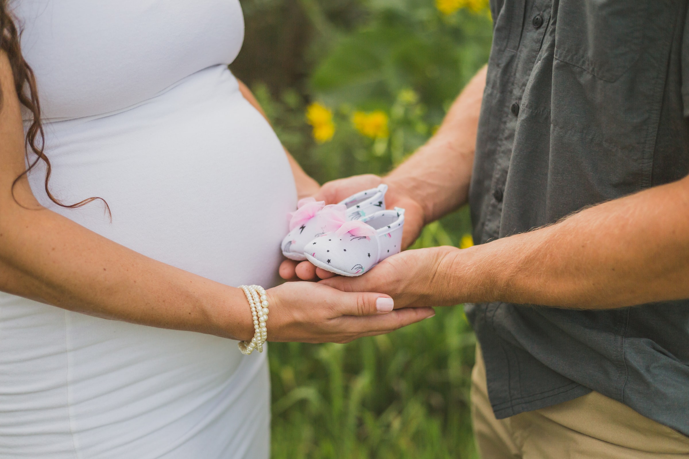 parents holding baby shoes